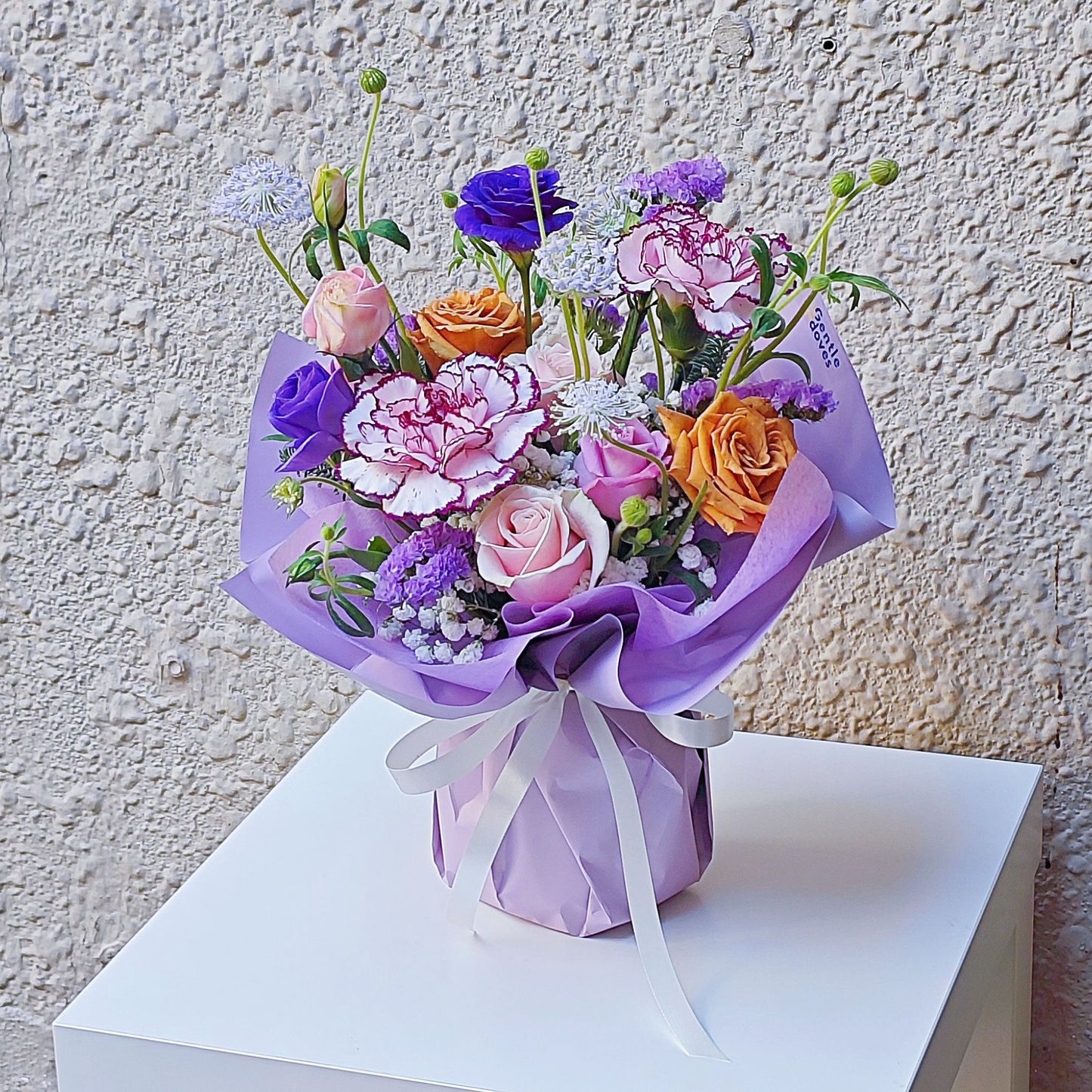 Assorted Purple Color Flowers in Small Vase Arrangement