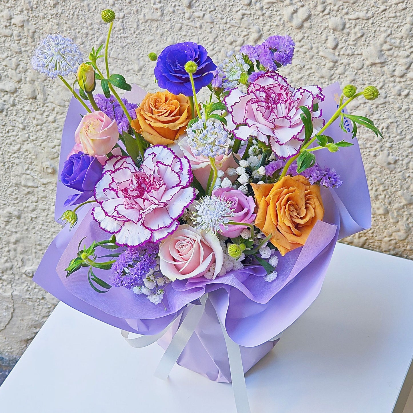 Assorted Purple Color Flowers in Small Vase Arrangement