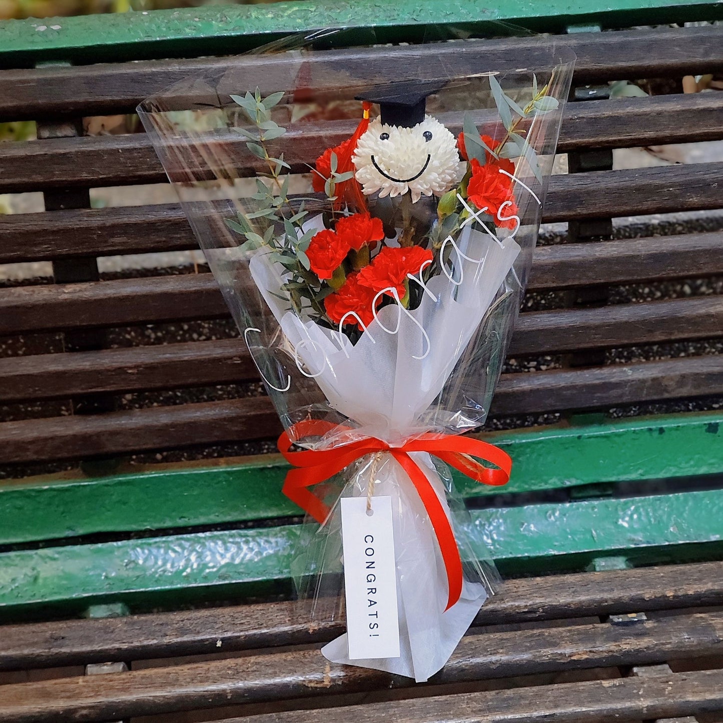 Graduated Smiley Face with Red Sprayed Carnations Small Bouquet