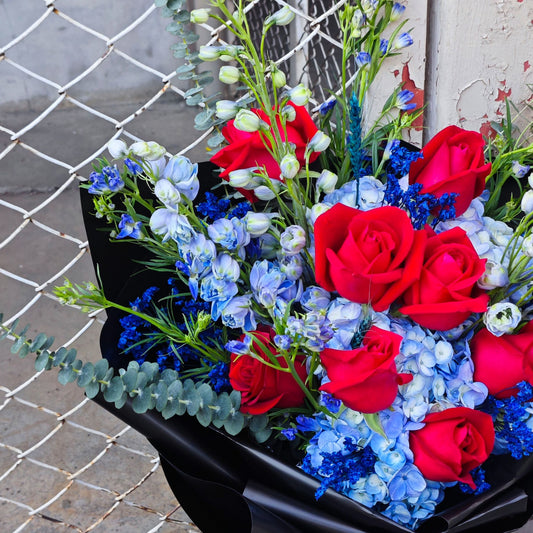 ช่อดอกไม้คละ ดอกไม้โทนสีน้ำเงินฟ้า และ กุหลาบสีแดง ห่อกระดาษสีดำ ช่อขนาดใหญ่