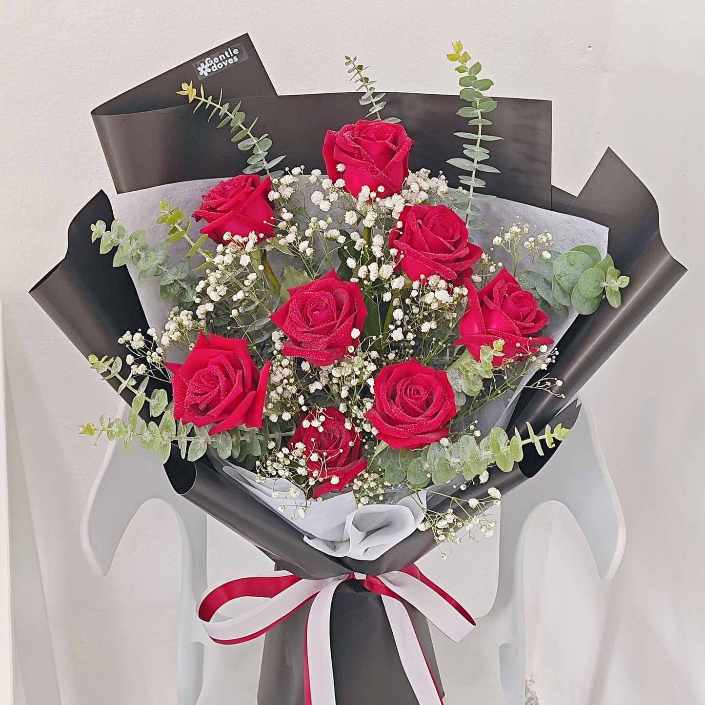 Eight Red Roses with Foliage in Black Paper Bouquet