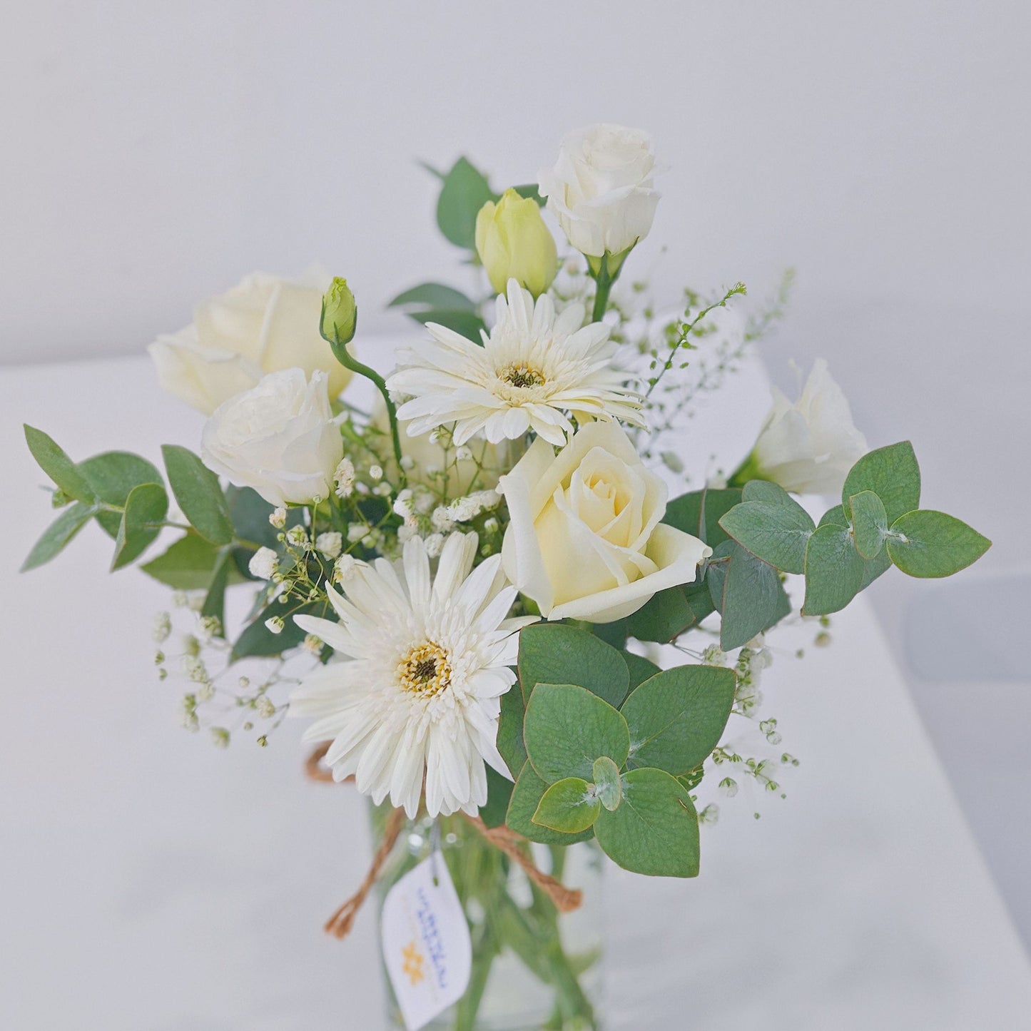 Assorted White Roses and Gerberas with Green Foliage in Small Vase Arrangement