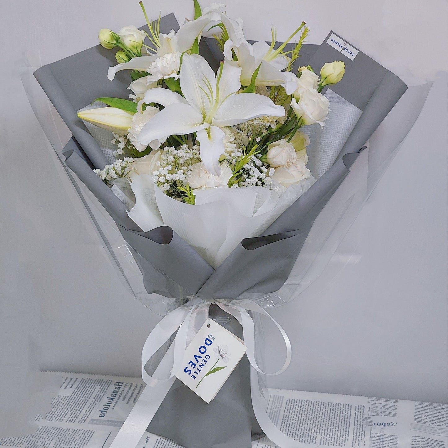 White Lilies with Assorted White Flowers in Gray Paper Bouquet