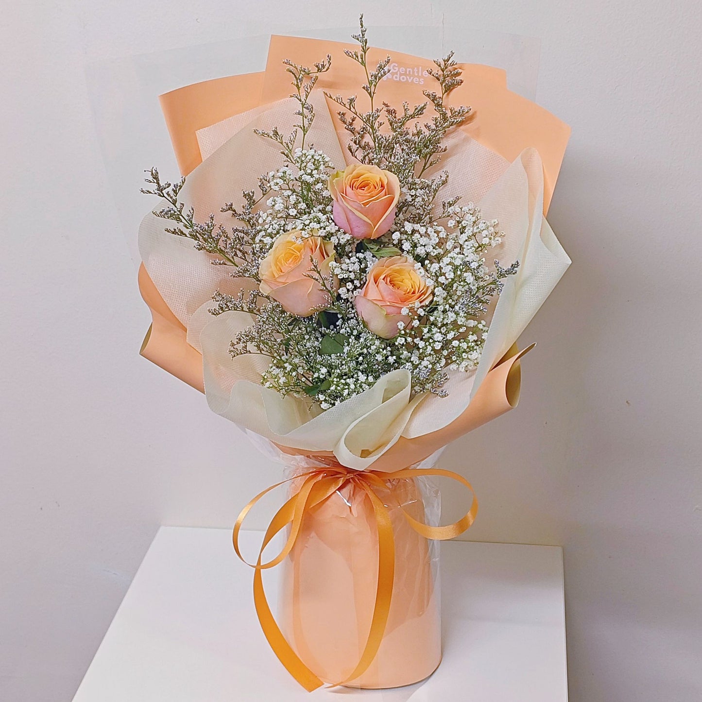 Three Creamy Yellow-Orange Roses with Caspia and Gypsophila in Orange Color Paper Bouquet