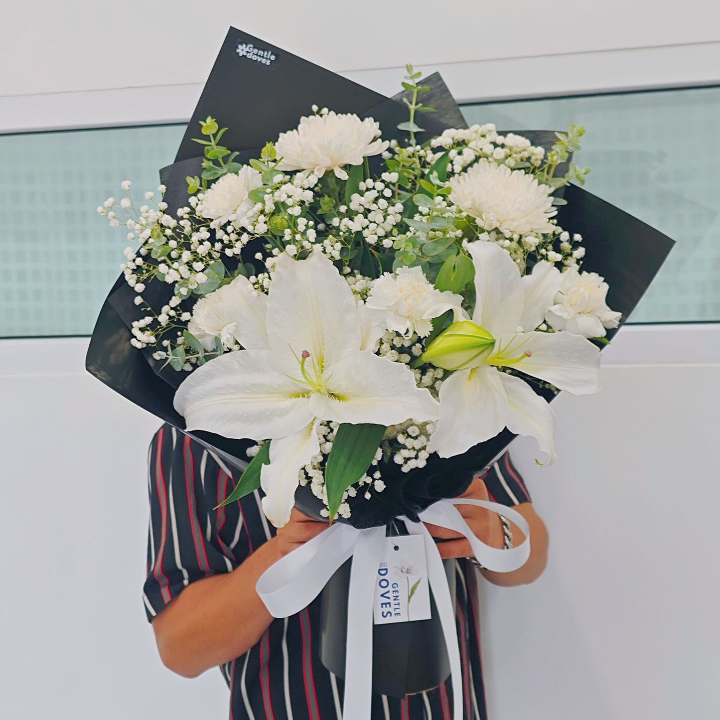White Lilies with White Flowers and Foliage in Black Paper Bouquet