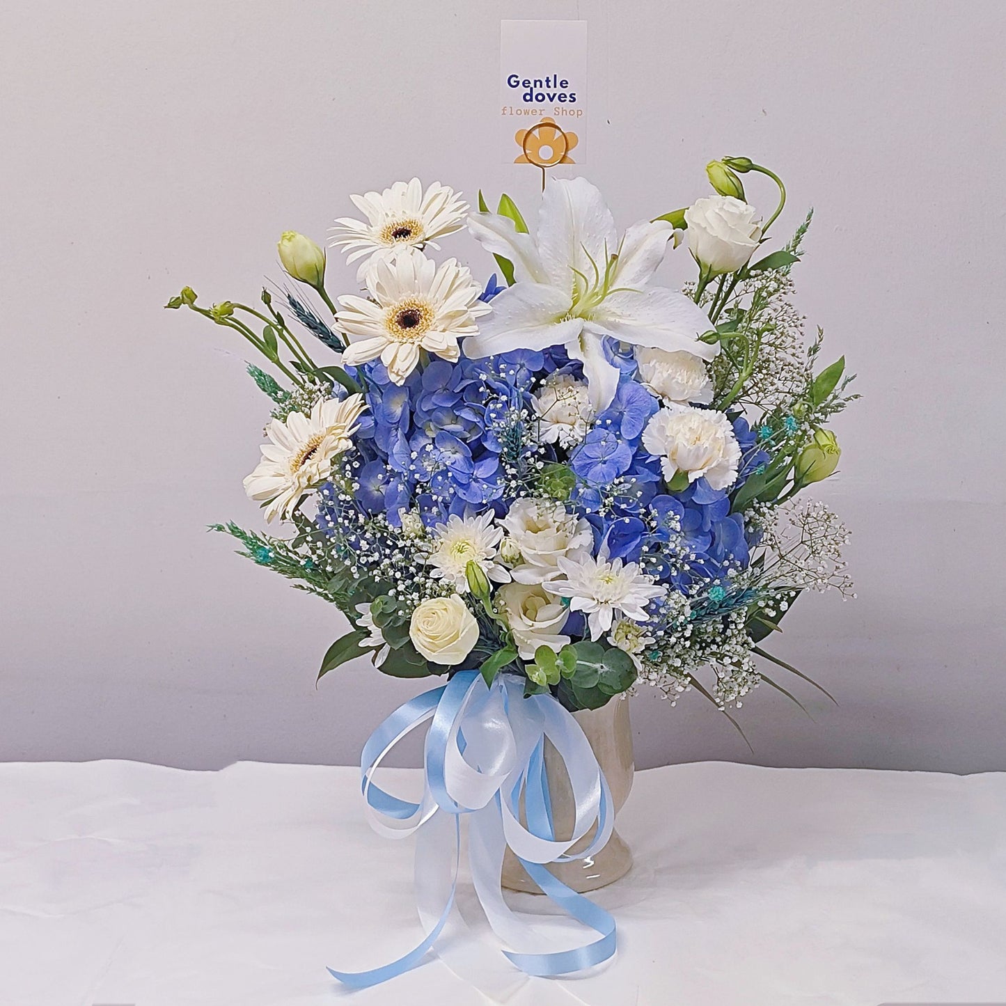 Assorted Blue and White Flowers in Medium Ceramic Vase Arrangement