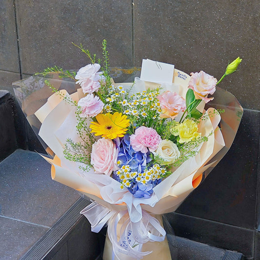 ช่อดอกไม้คละ โทนสีชมพู และ สีเหลือง กับ ไฮเดรนเยียสีฟ้า ห่อกระดาษสีเหลืองอ่อน