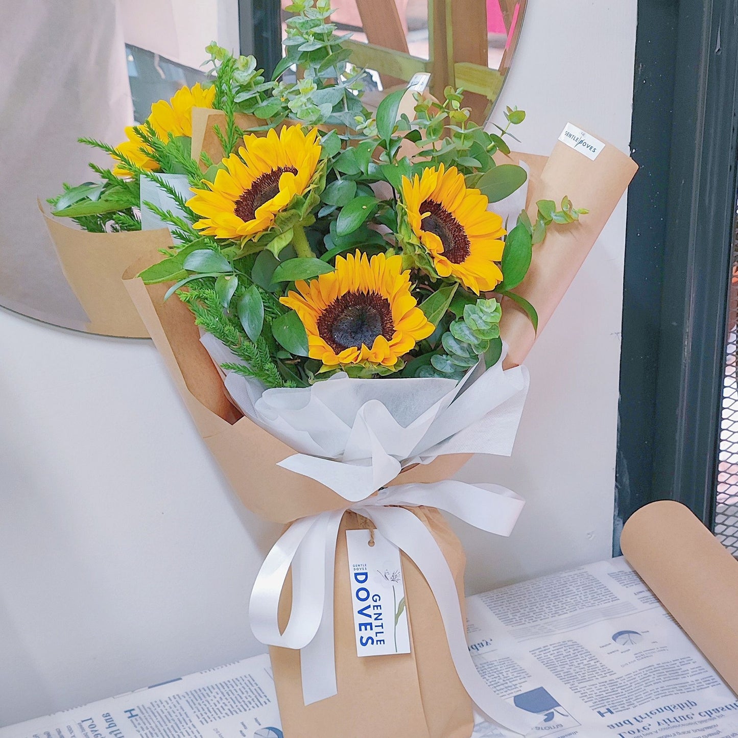 Three Sunflowers with Green Foliage in Kraft Paper Bouquet