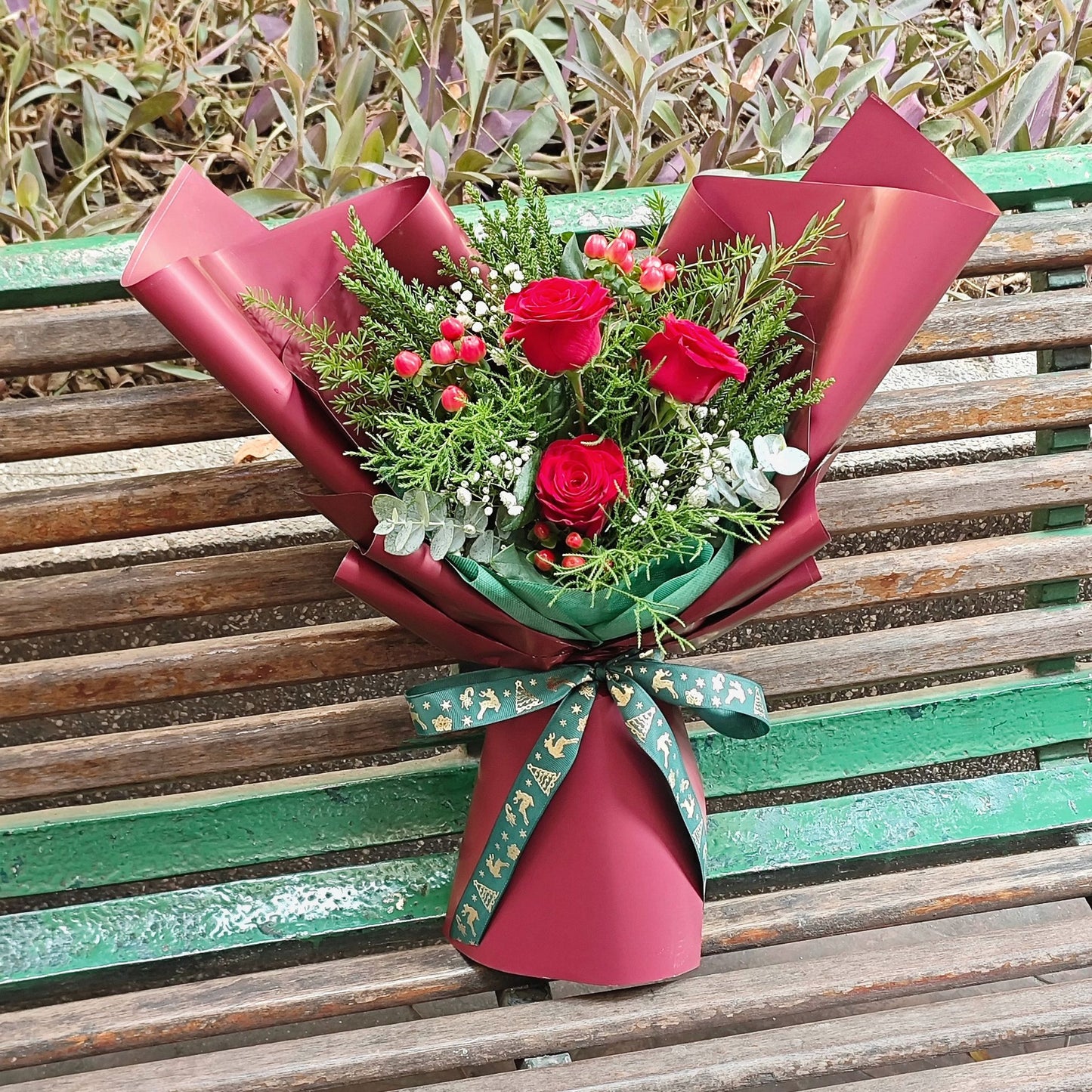 Three Imported Red Roses with Green Pines and Red Berries Bouquet