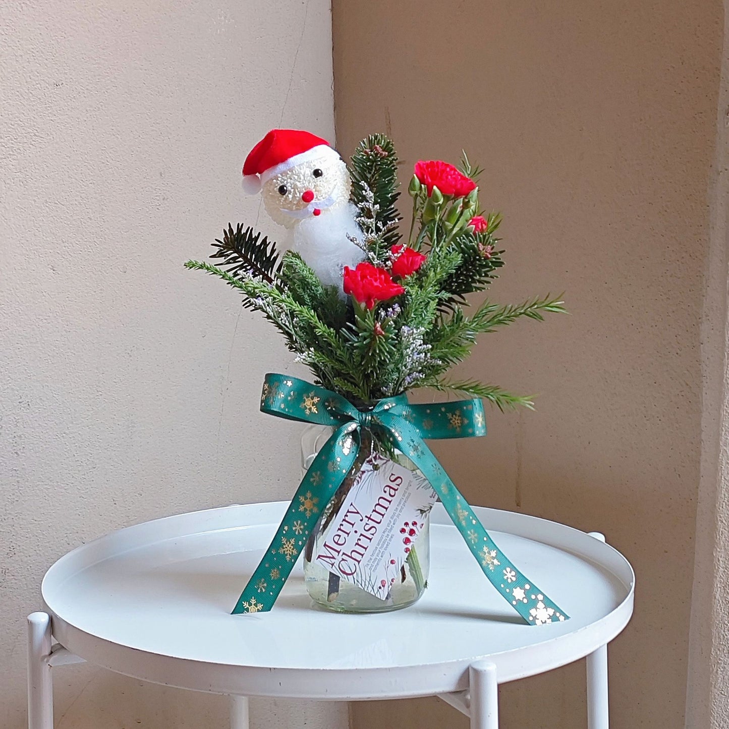 Santa with Green Pines and Red Flowers Small Vase Arrangement