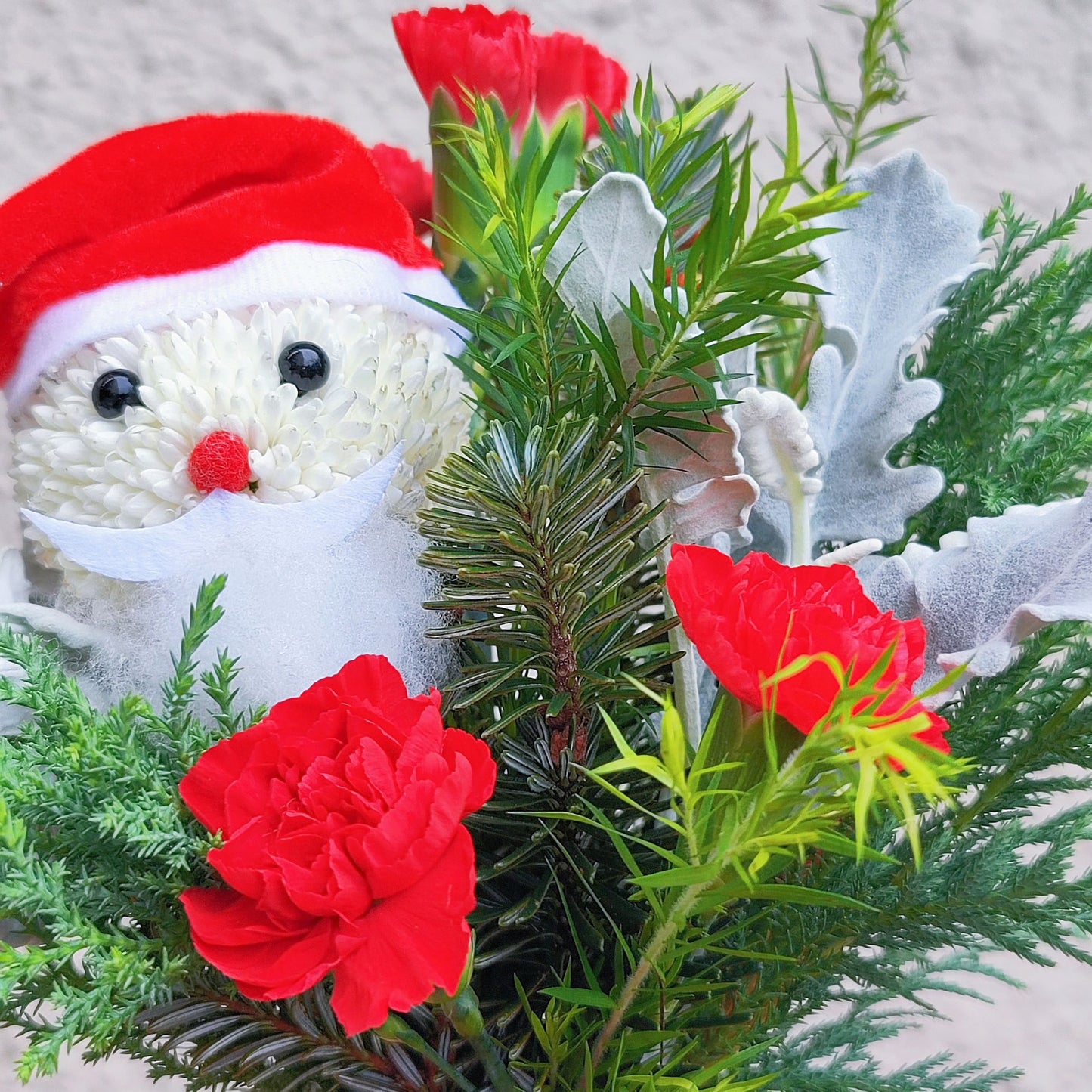 Santa with Green Pines and Red Flowers Small Vase Arrangement