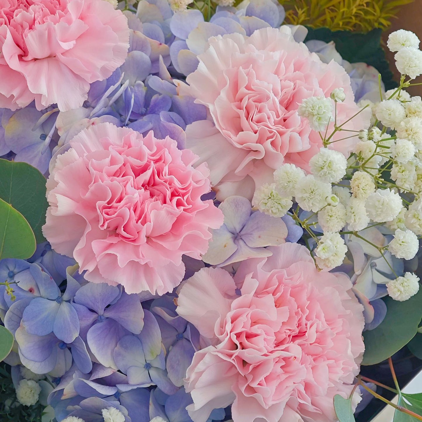 Soft Purple Hydrangeas with Soft Pink Carnations and Green Foliage in Kraft paper Bouquet