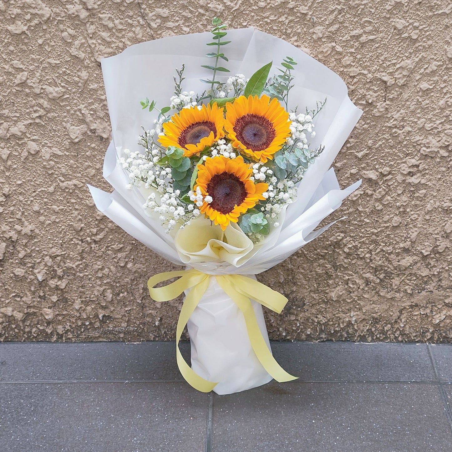 Three Sunflowers with Gypsophila and Eucalyptus in White Paper Bouquet