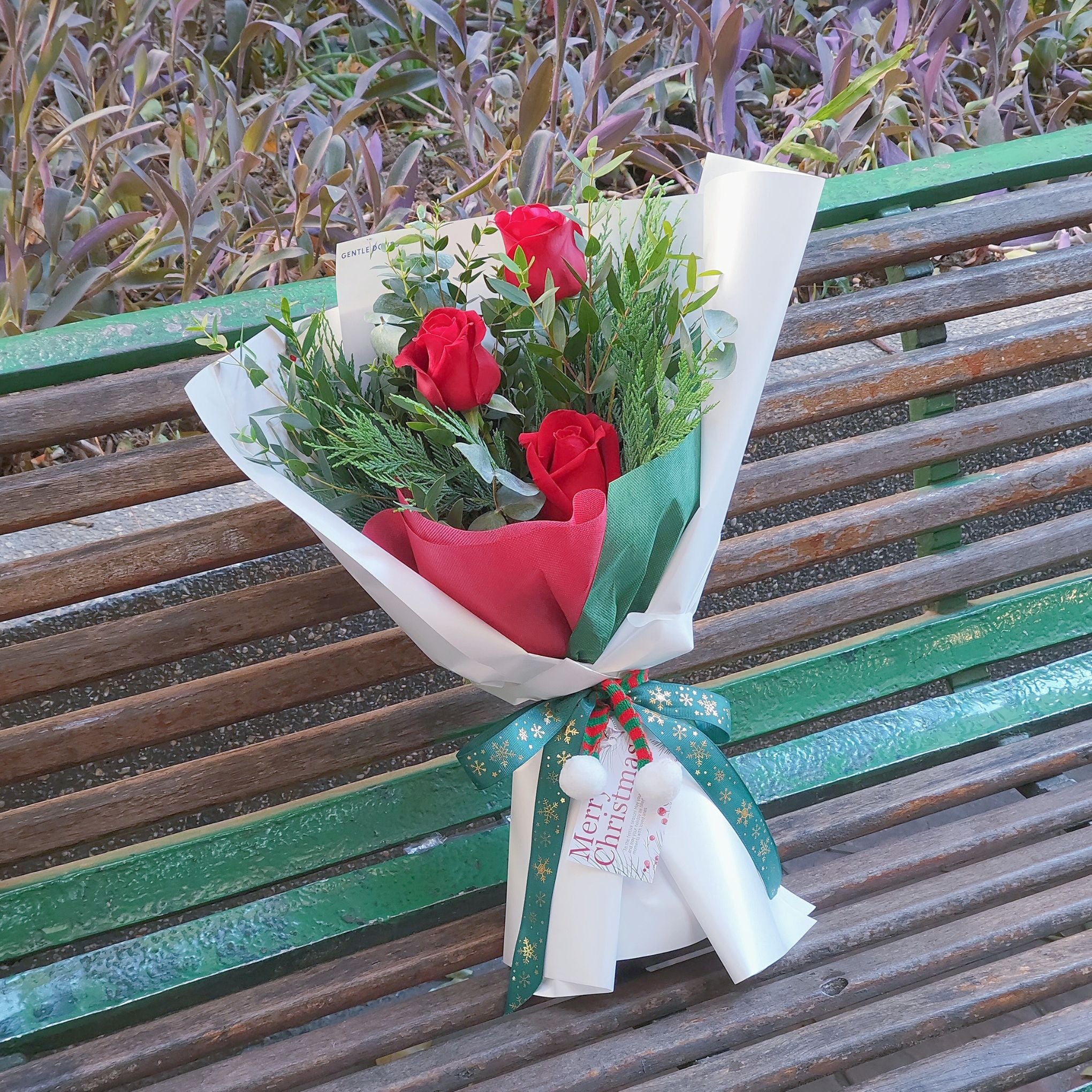 Three Red Roses with Green Pines and Foliage Christmas Theme Bouquet