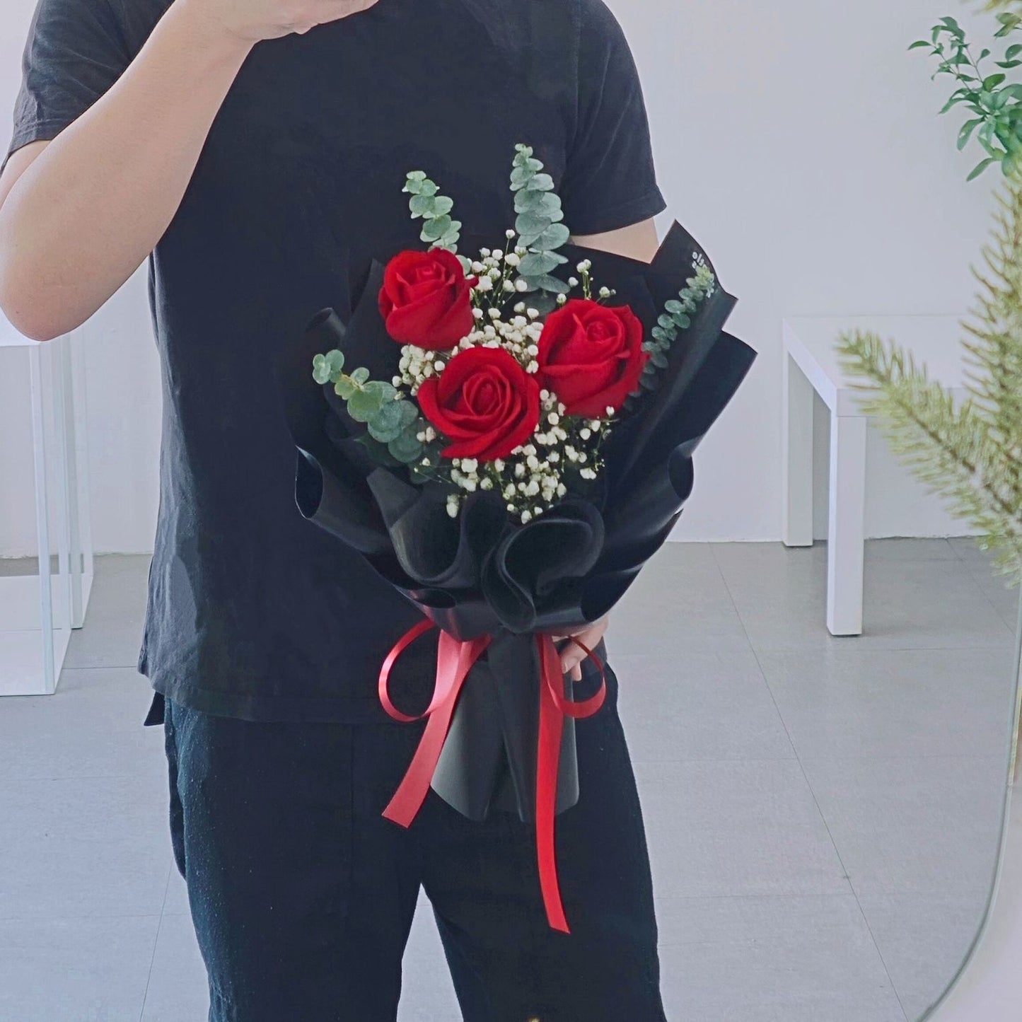 Three Red Roses with Gypsophila and Eucalyptus in Black Paper Bouquet