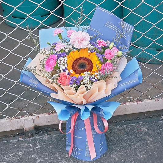 Sunflower with Assorted Pink and Purple Flowers in Newspaper Pattern Bouquet