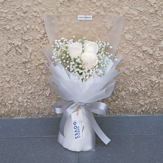 Three White Roses with Gypsophila in Matte Paper Bouquet