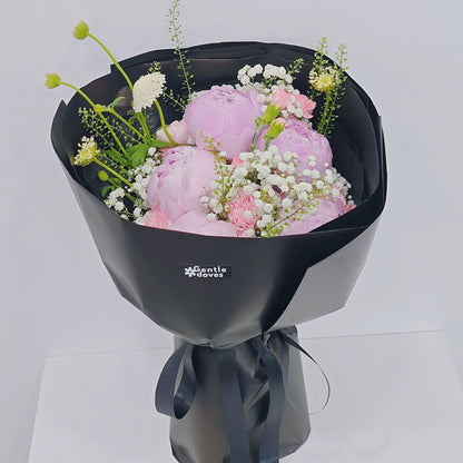 Five Soft Pink Peonies with Assorted Pink Flowers and Foliage in Black Paper Bouquet