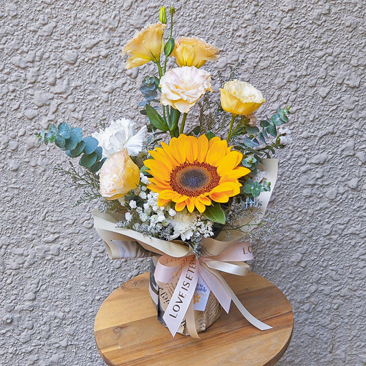 Single Sunflower with Soft Yellow and Green Foliage Medium Vase Arrangement