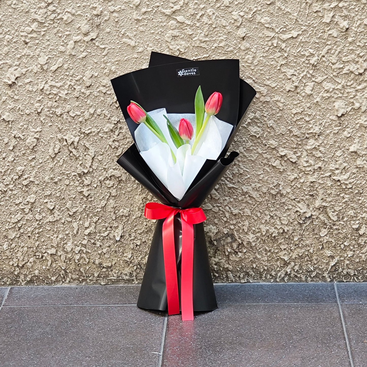 Three Red Tulips in Black Paper Bouquet