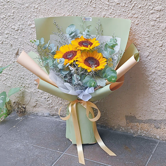 Three Sunflowers with Eucalpytus and Caspia in Green Paper and Soft Orange Paper Bouquet