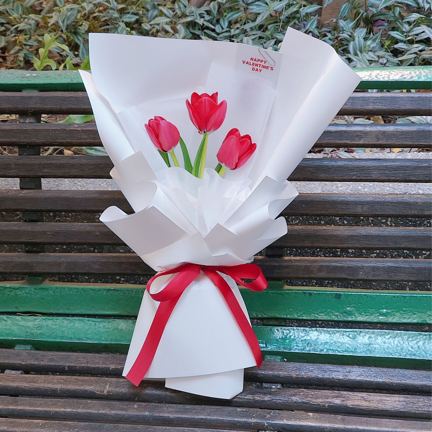 Three Red Tulips in White Paper Bouquet