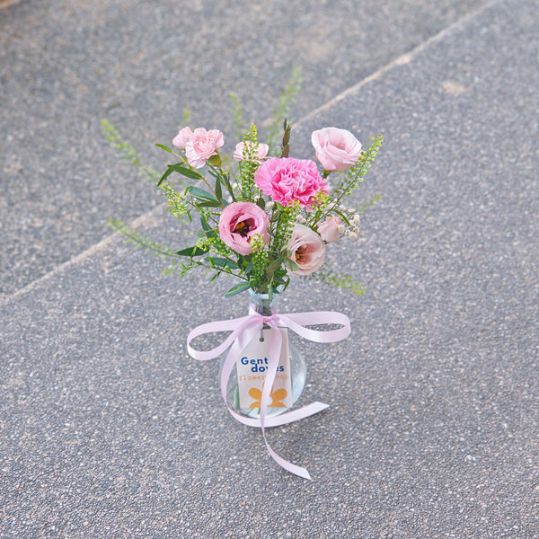 Assorted Vivid Pink Flowers with Green Foliage in Mini Vase Arragement