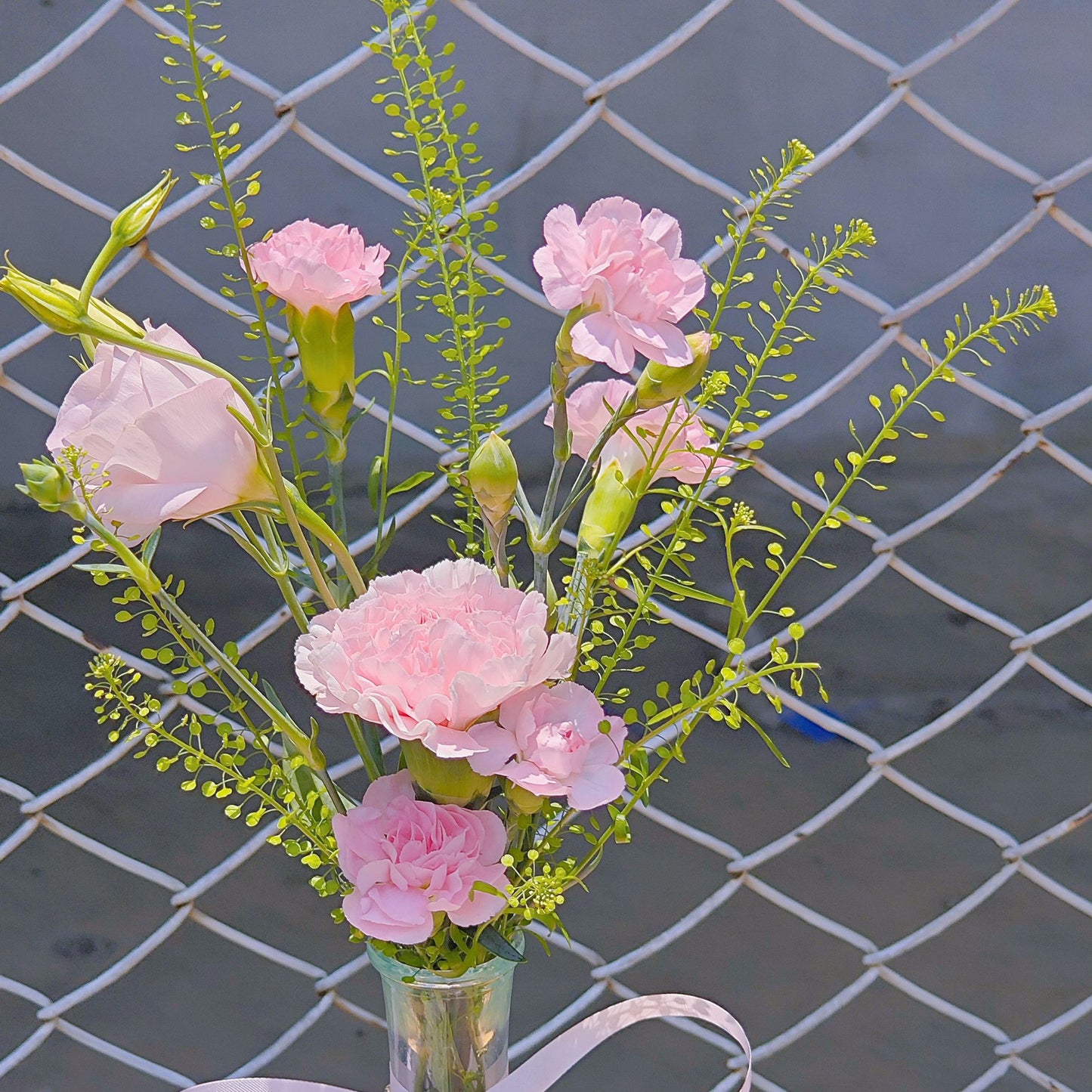 Assorted Pink Flowers with Green Foliage in Small Vase Arrangement