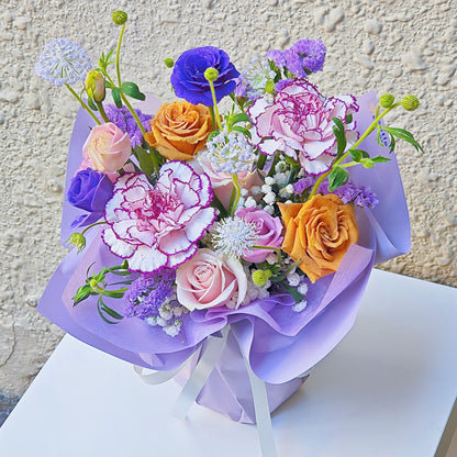 Assorted Purple Color Flowers in Small Vase Arrangement