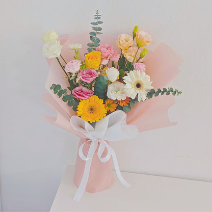 Assorted Yellow and Orange Flowers in Soft Pink Paper Bouquet