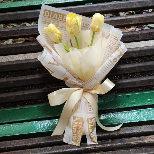 Three Soft Yellow Tulips in Newspaper Wrapping Bouquet