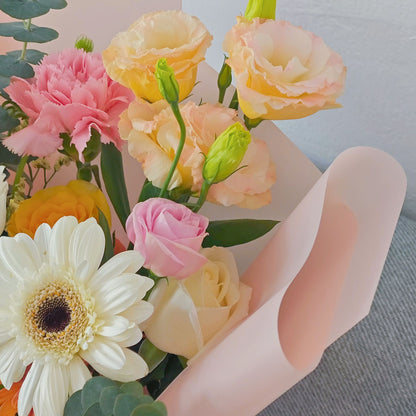Assorted Yellow and Orange Flowers in Soft Pink Paper Bouquet