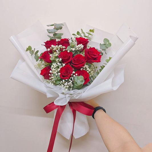 Ten Imported Red Roses with Green Foliage in White Paper Large Bouquet