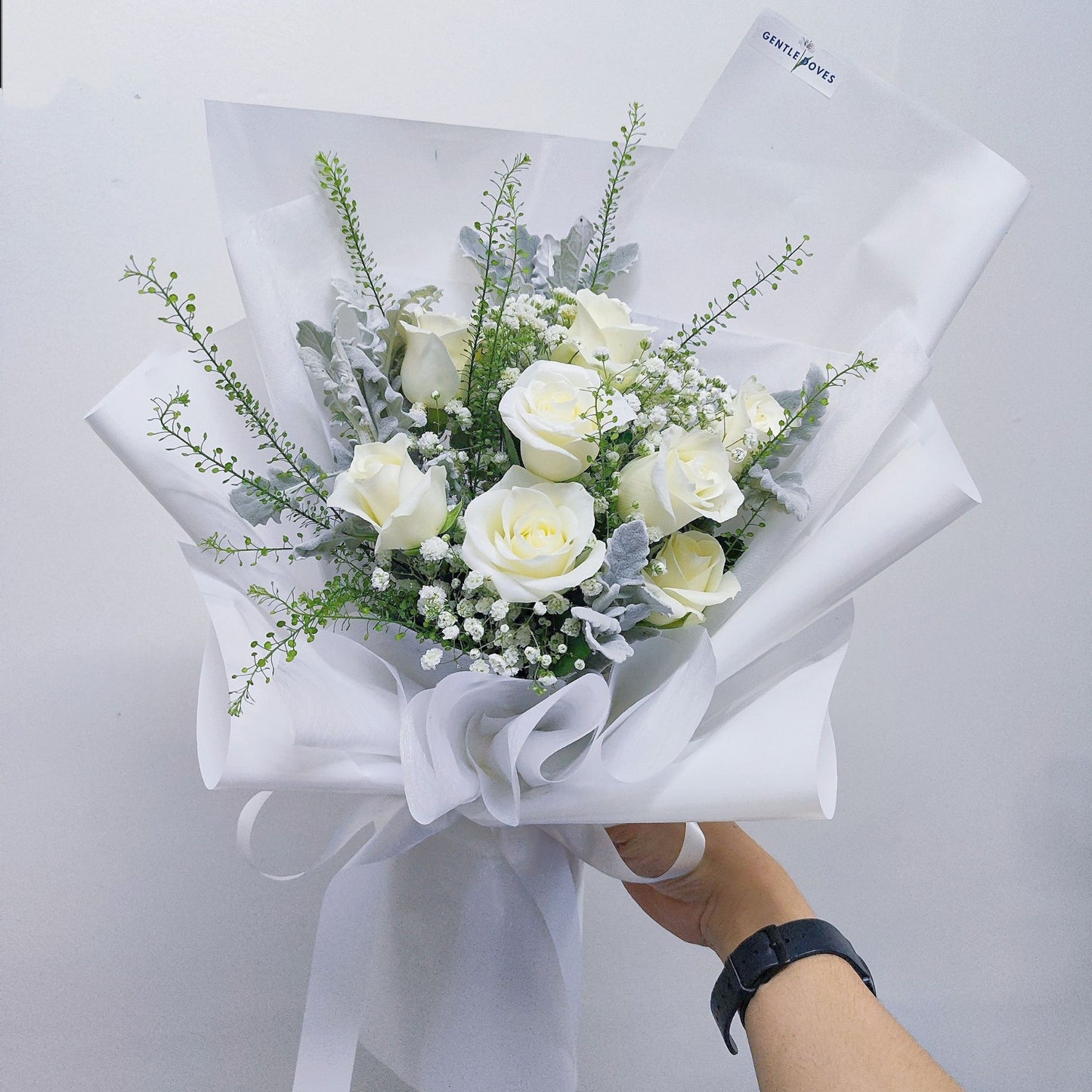 Ten White Roses with Foliage in White Paper Bouquet