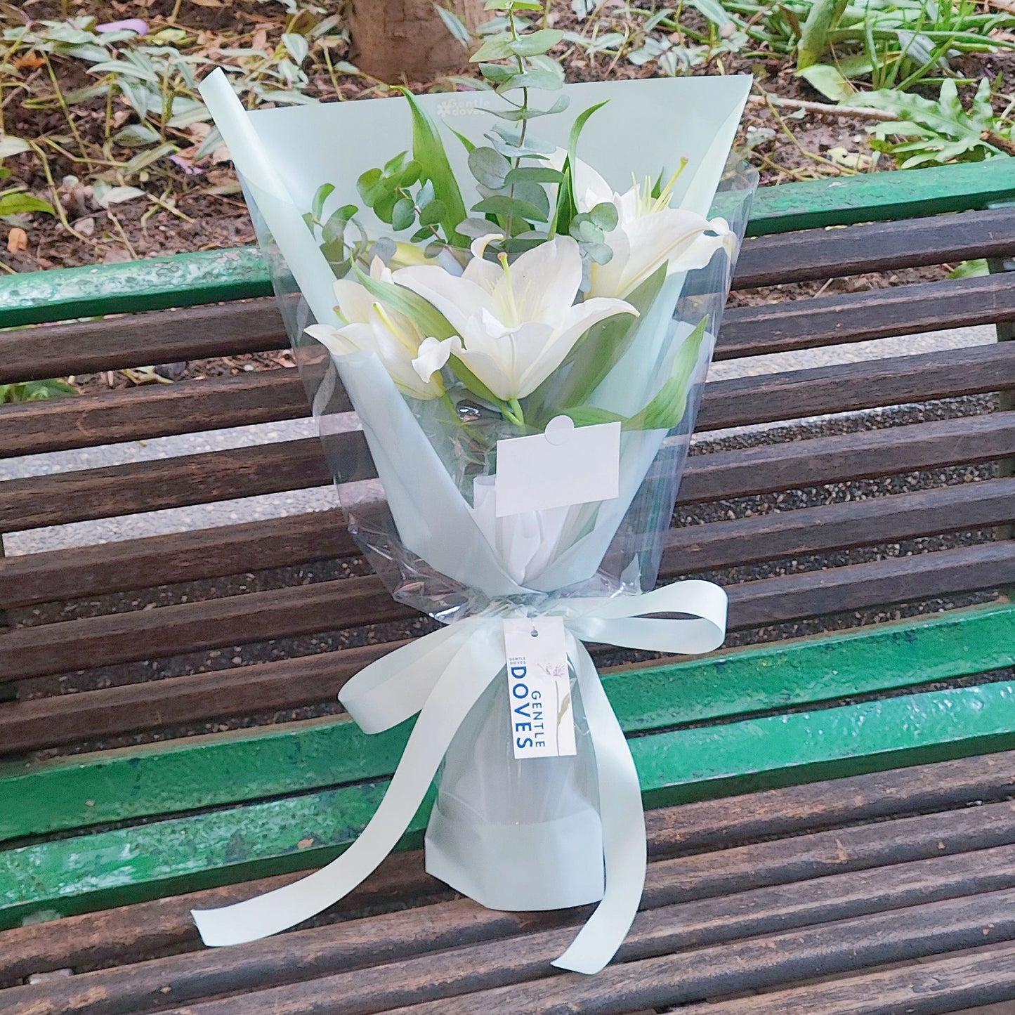 White Lilies with Eucalyptus in Green Paper Bouquet