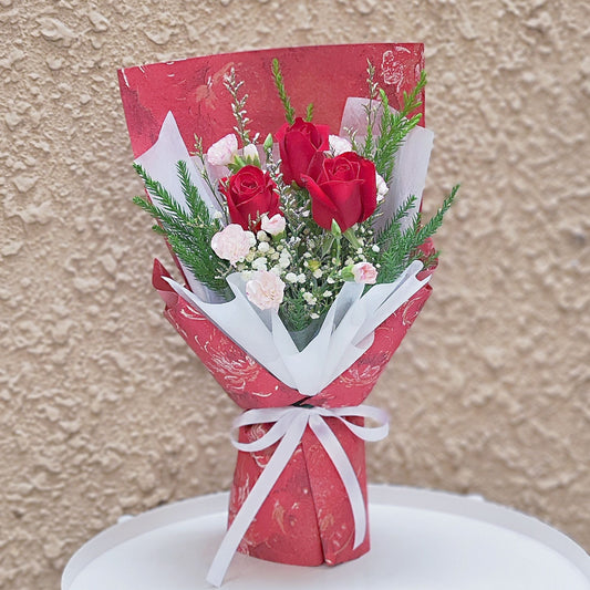 Three Red Roses with Foliage in Red Floral Pattern Bouquet