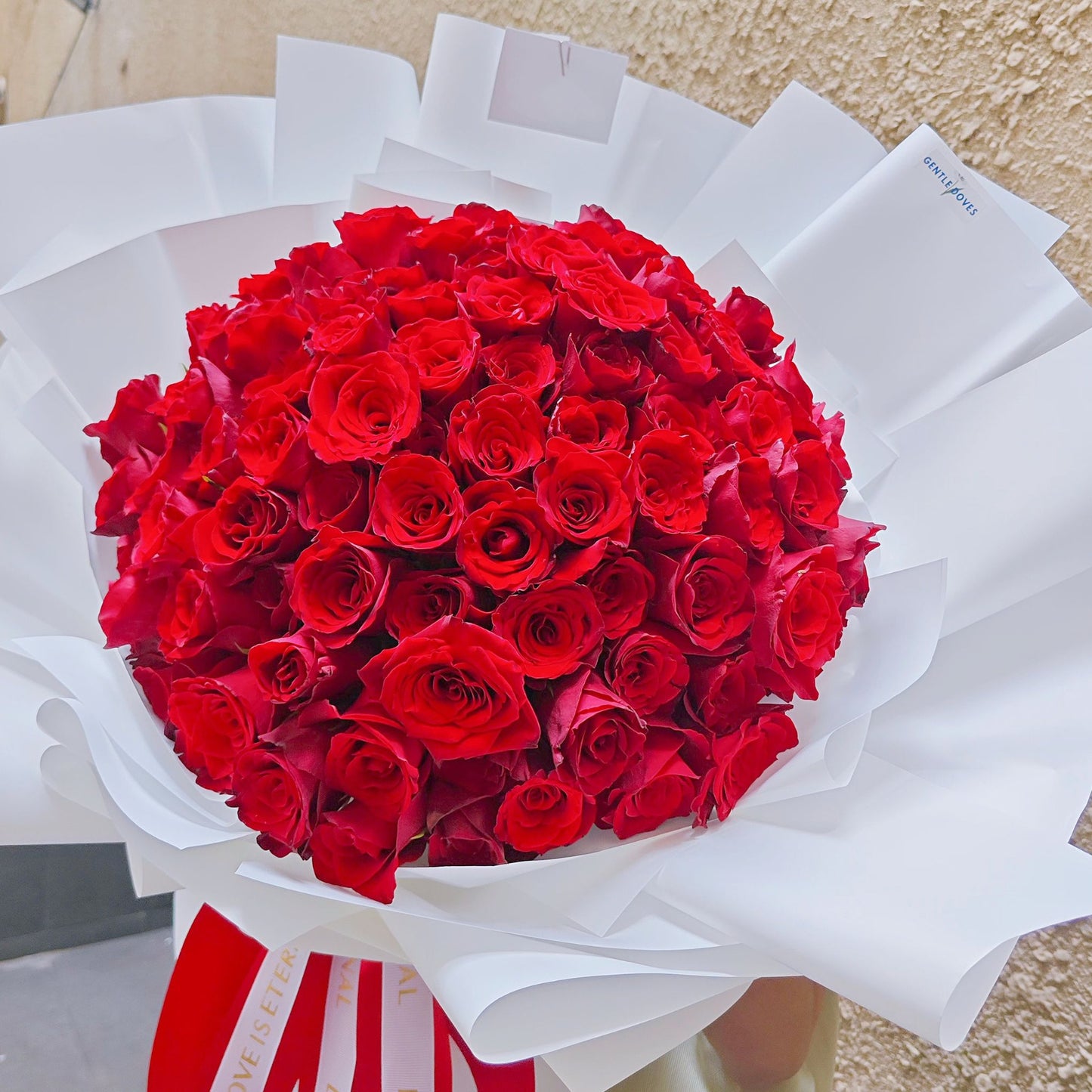 Ninety - Nine Red Roses in White Paper Bouquet