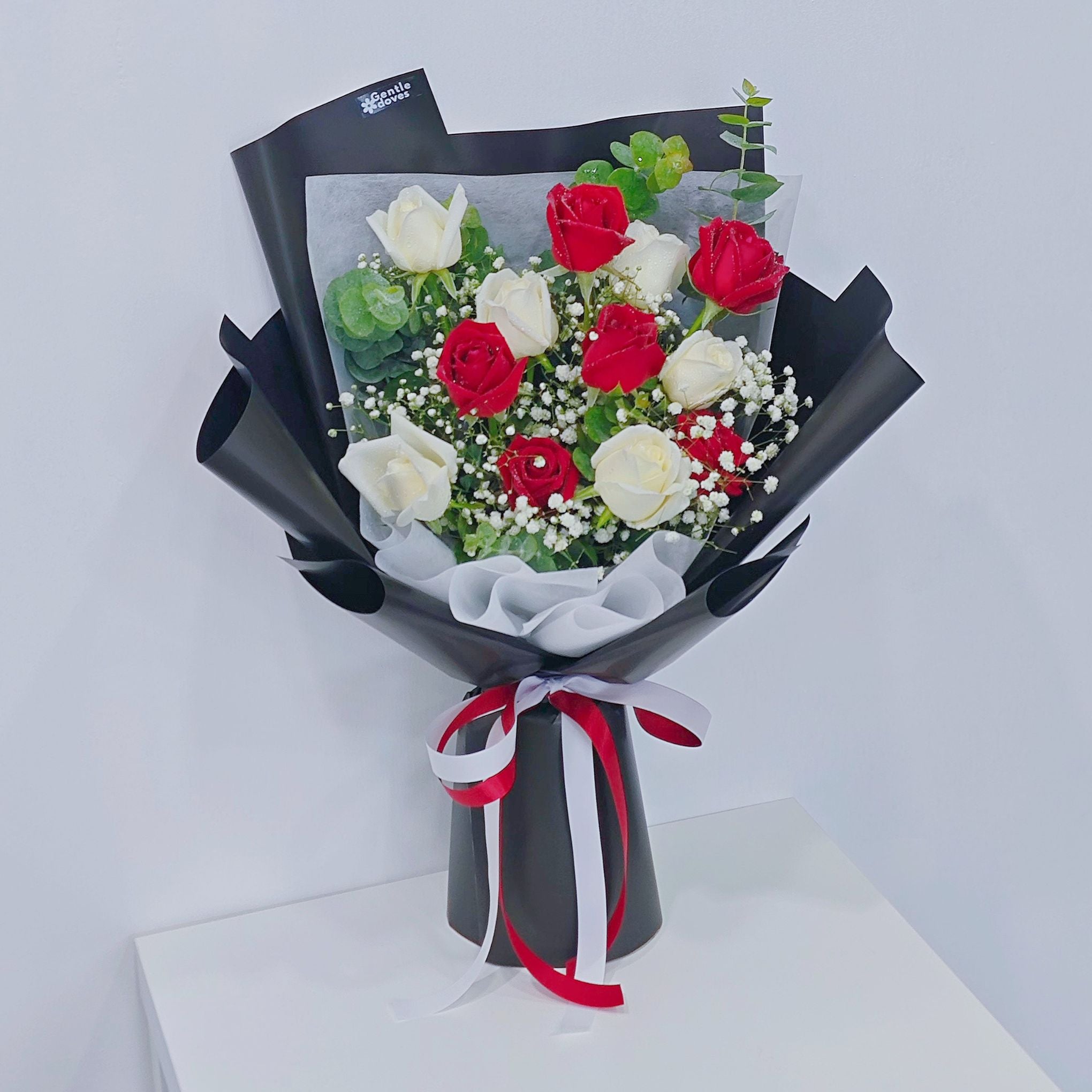 ช่อดอกกุหลาบ สีแดง และ สีขาว 12 ดอก แซมยูคาลิปตัส และ ยิปโซฟิลล่า ห่อกระดาษสีดำ
