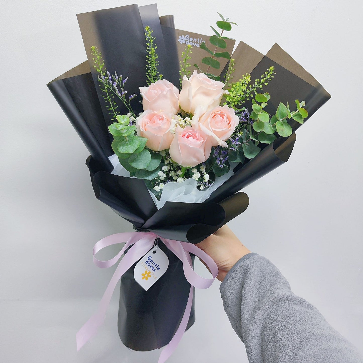 Five Soft Pink Roses with Foliage in Black Paper Bouquet