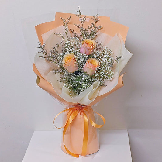 Three Creamy Yellow-Orange Roses with Caspia and Gypsophila in Orange Color Paper Bouquet