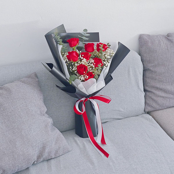 Eight Red Roses with Foliage in Black Paper Bouquet