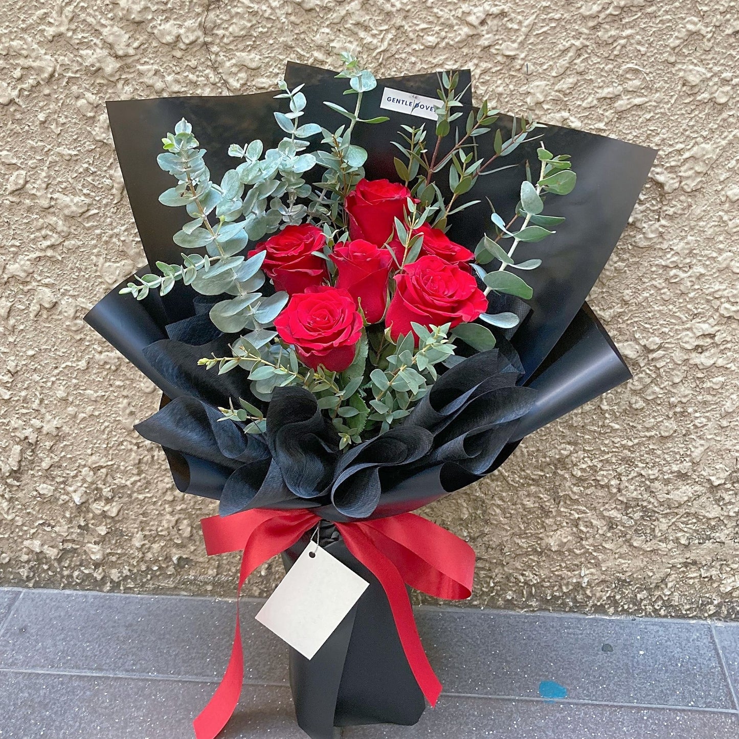 Six Imported Red Roses with Eucalyptus in Black Paper Bouquet