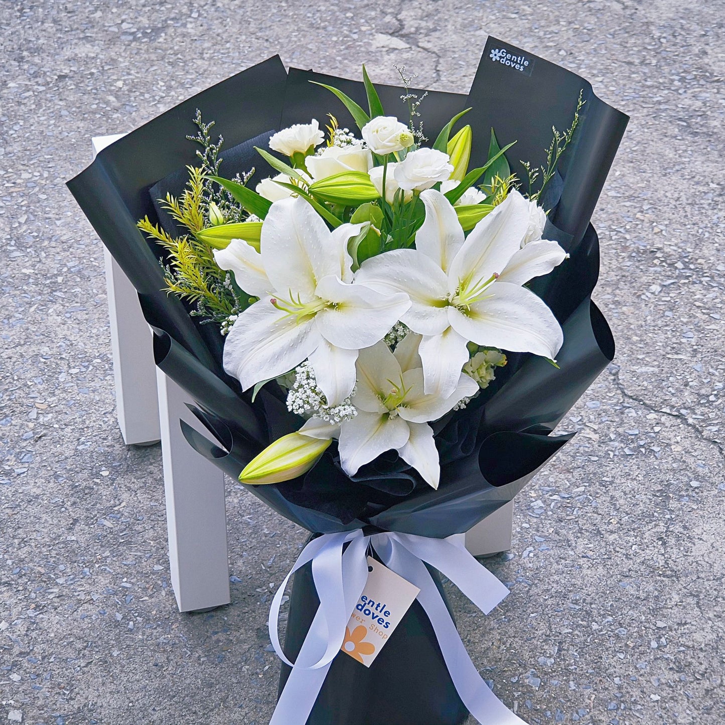 White Lilies with Assorted White Flowers in Black Paper Bouquet