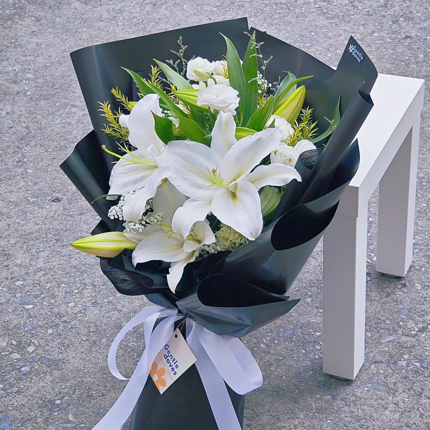 White Lilies with Assorted White Flowers in Black Paper Bouquet