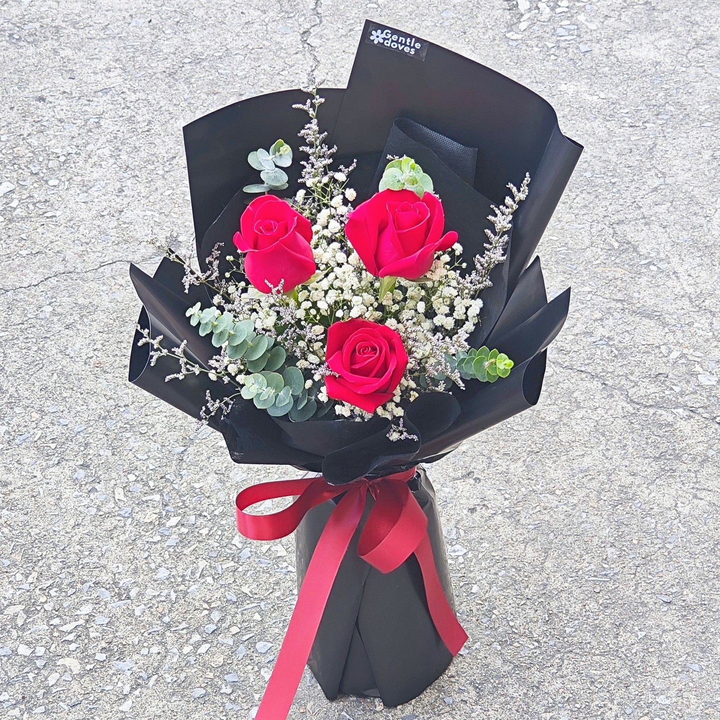 Three Red Roses with Caspia, Gypsophila and Eucalyptus in Black Paper Small Bouquet