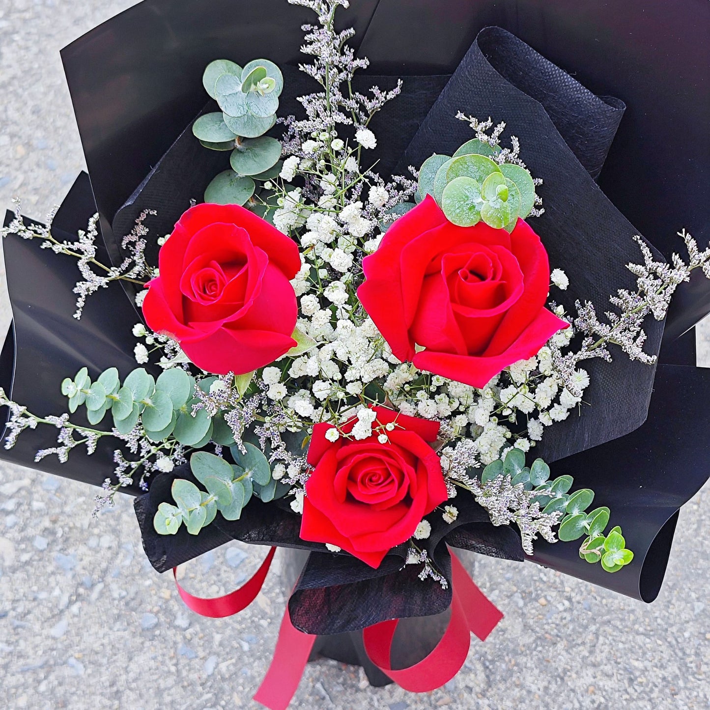 Three Red Roses with Caspia, Gypsophila and Eucalyptus in Black Paper Small Bouquet