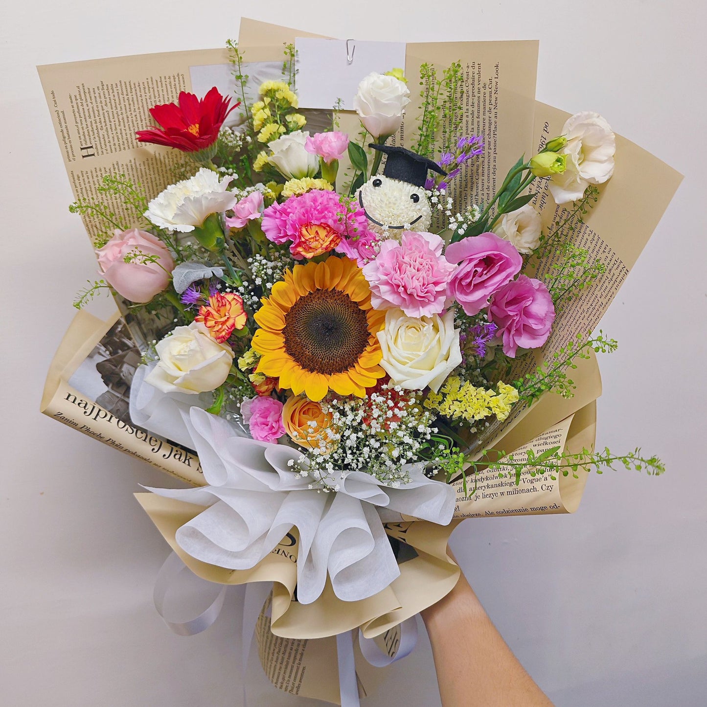 Assorted Colorful Flowers with Graduated Smiley Face in Golden Newspaper Bouquet