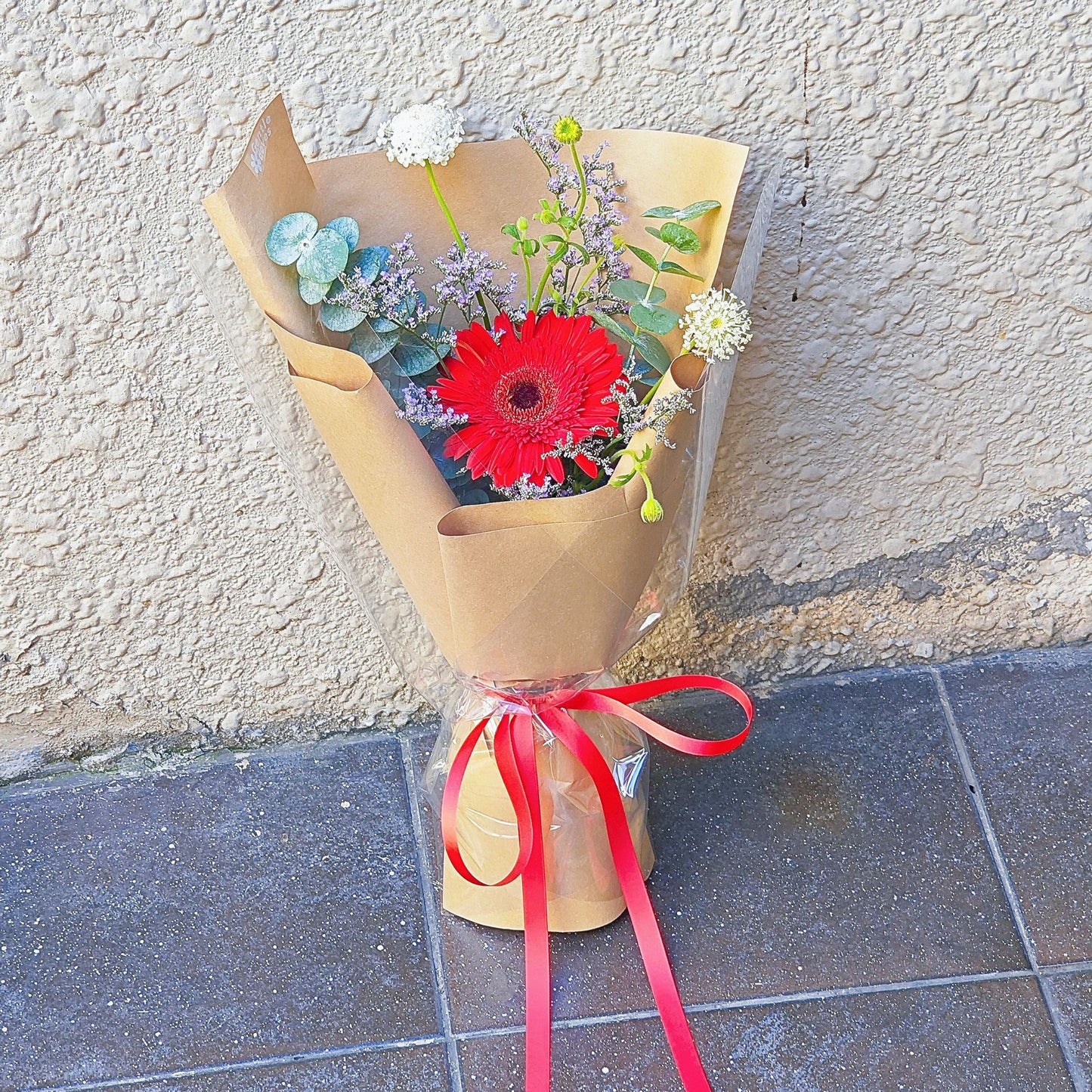 Single Red Gerbera with Foliage in Craft Paper Small Bouquet