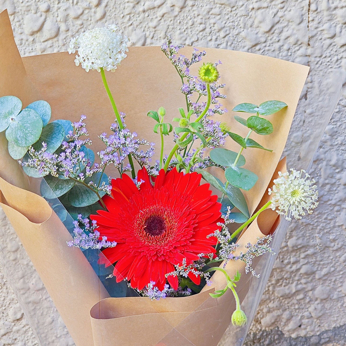 Single Red Gerbera with Foliage in Craft Paper Small Bouquet