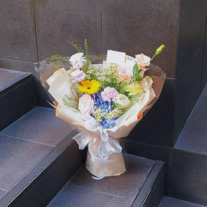 Assorted Pink and Yellow with Blue Hydrangea in Soft Yellow Paper Bouquet